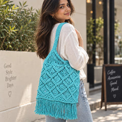 "Blue macramé 
shoulder bag with an intricate geometric knotted pattern,  braided straps, and fringe detailing along the bottom."

