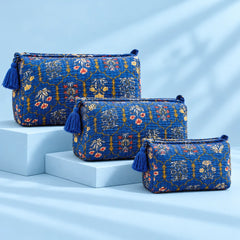 "Set of three royal blue
 quilted fabric pouches featuring intricate floral and ornamental prints with tassel details and arranged in different sizes."
