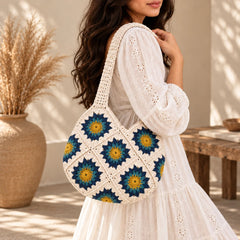 "White crochet bag featuring
 colourful floral granny-square patterns in blue, and yellow, with a textured handmade design and bohemian-inspired style."
