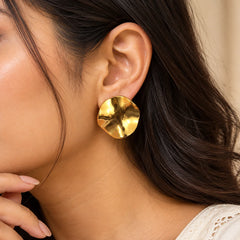 Gold sculpted disc earrings featuring an abstract wavy design and a high-shine polished finish.
