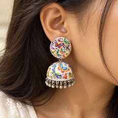 White butterfly print jhumka earrings with multicolour butterfly patterns, dome-shaped drops, and silver-tone dangling charms.
