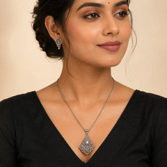 "Oxidised silver-tone necklace 
and earrings set featuring an intricate triangular pendant with ghungroo-style danglers and matching ethnic stud earrings."
