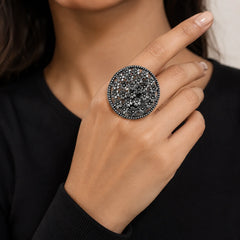 "Oxidised silver-tone statement
 ring featuring an intricate oval openwork design with clustered floral detailing and an antique finish."

