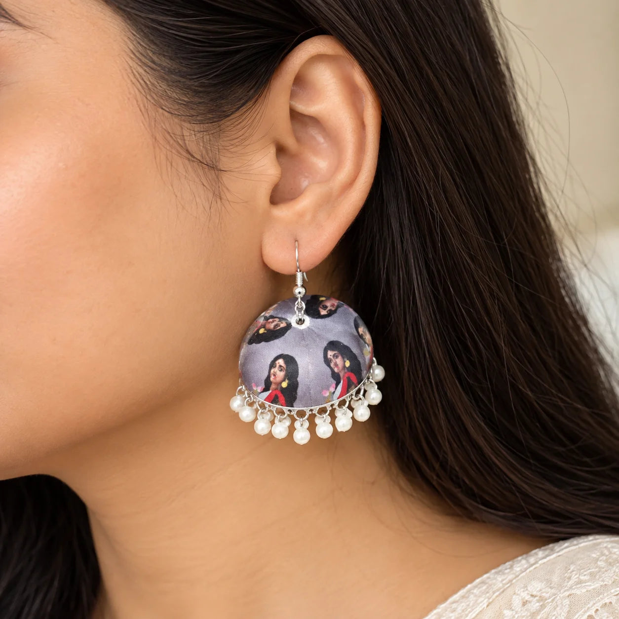 Grey dome-shaped jhumka earrings featuring traditional Goddess portrait prints and delicate white bead danglers along the edges
