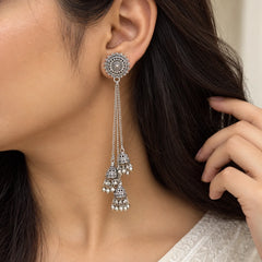 "Pair of silver-toned 
statement earrings featuring intricate circular designs, multiple cascading chain strands, and ornate jhumka-style drops."

