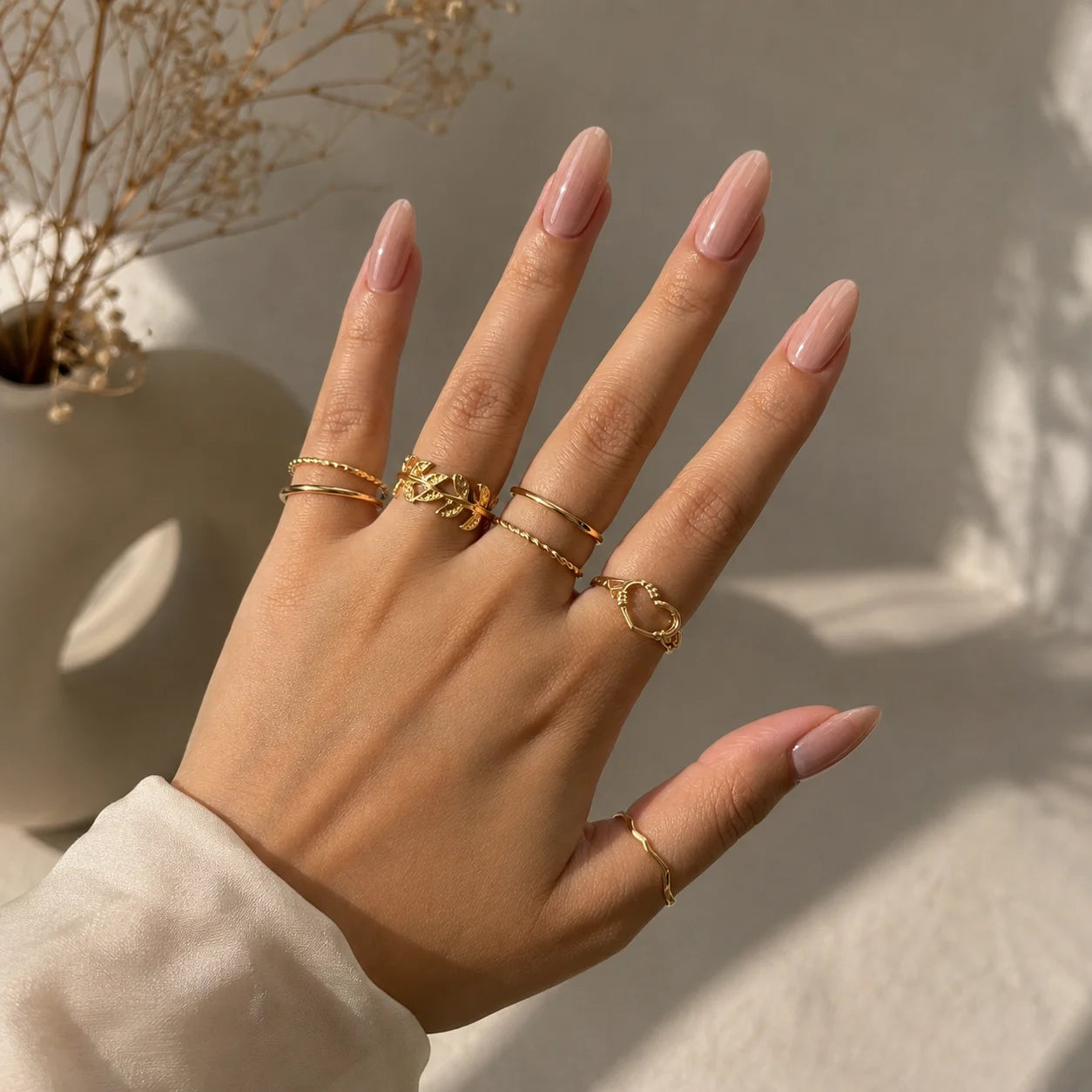 "Golden ring combo for women
 featuring heart and floral accents, wavy and minimalist textured stackable ring designs."
