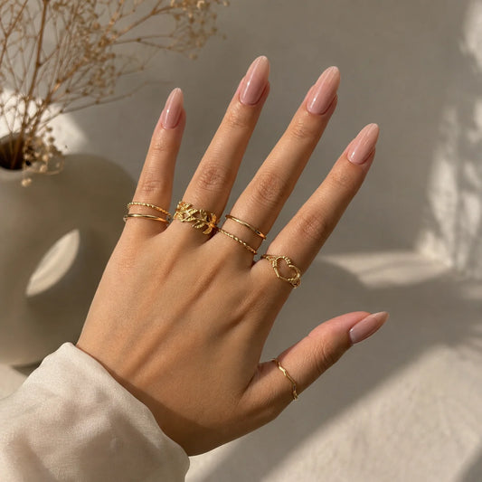 "Golden ring combo for women
 featuring heart and floral accents, wavy and minimalist textured stackable ring designs."

