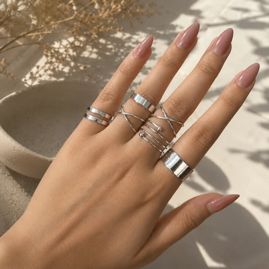"Silver ring combo
 for women featuring spiral, layered loop and bold band designs with a modern minimalist finish."
