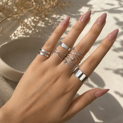 "Silver ring combo
 for women featuring spiral, layered loop and bold band designs with a modern minimalist finish."
