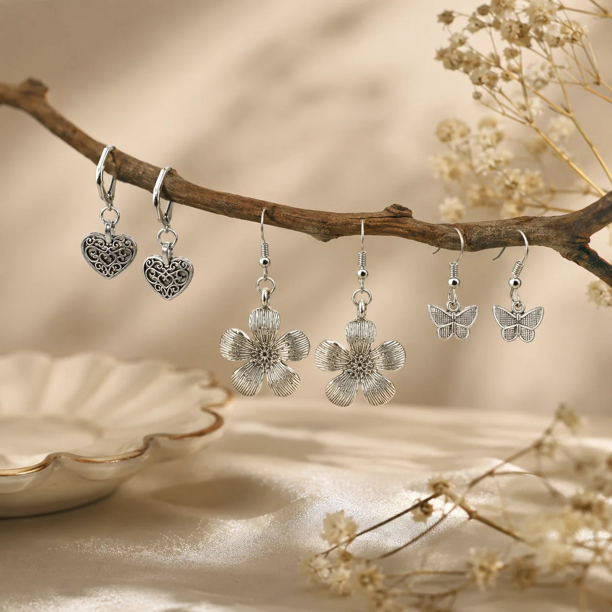 Set of 3 oxidised silver earring pairs. Butterfly hook earrings, filigree heart lever-back earrings, and large flower hook earrings. Antique silver feminine combo.

