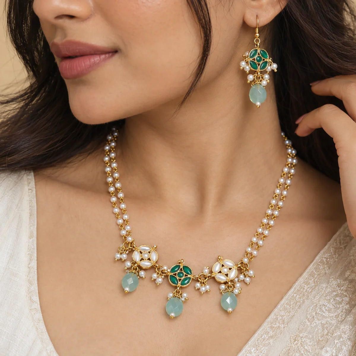 Sea green kundan pearl necklace set with layered white pearl strands, green and white floral detailing, sea green bead drops, and matching earrings.
