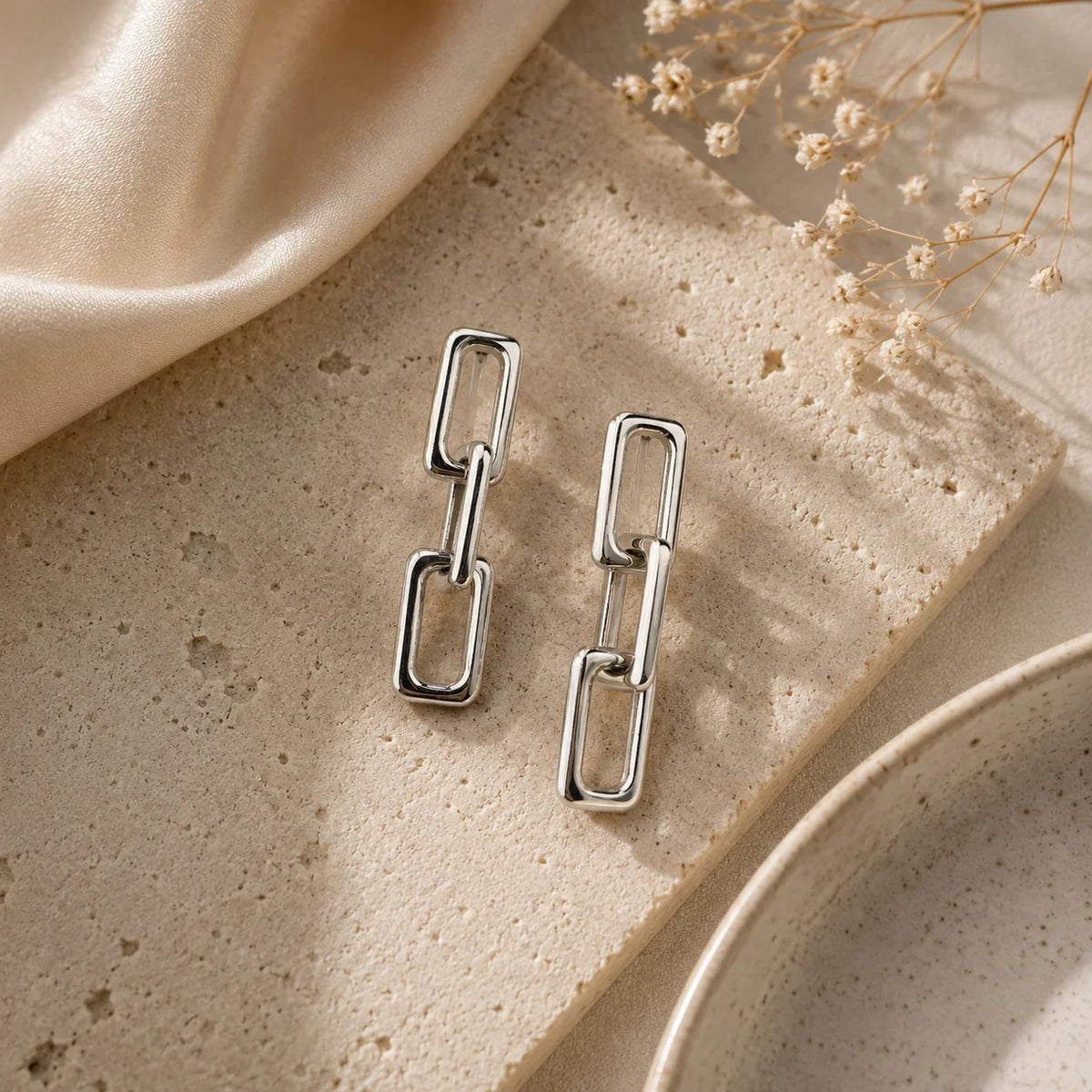 "Silver-tone chain link dangle 
earrings featuring a polished 
interlocking geometric design. Modern lightweight
 earrings for women, perfect for everyday wear."
