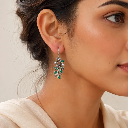 "Oxidised silver-tone leaf drop
 earrings with green stone accents and intricate botanical detailing. Nature-inspired ethnic earrings for women, perfect for everyday wear, festive occasions, office styling, casual outings, and pairing with kurtas, sarees, and Indo-western outfits."

