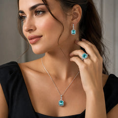 "Silver-tone turqoise blue crystal 
jewellery set featuring a blue gemstone pendant necklace, matching crystal drop earrings, and a coordinating statement ring. Elegant fashion jewellery set for women, perfect for weddings, parties, festive occasions, evening wear, and gifting."
