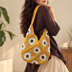 "Mustard yellow crochet
 bag with a colorful floral pattern in white, grey and brown, featuring  matching crochet handles."
