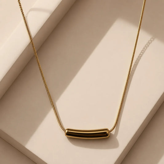 "Minimalist gold-tone bar
 necklace featuring a sleek
 polished bar pendant on a 
delicate snake chain.
 Elegant and lightweight 
women's fashion jewellery,
 perfect for everyday wear,
 office looks, layering, and
 special occasions."
