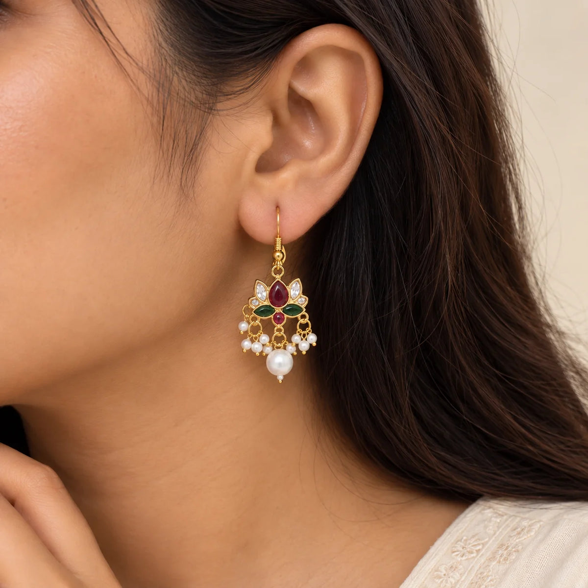 "Gold-toned floral earrings
 featuring ruby-red and emerald-green enamel accents, sparkling clear stones, delicate white pearl beads, and large pearl drops."
