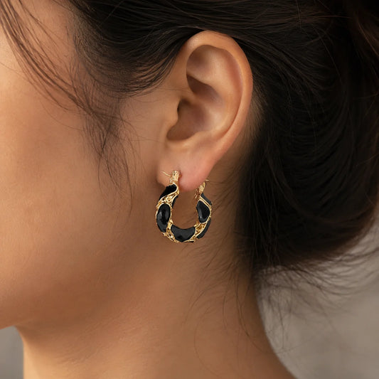 "Gold-tone hoop earrings
 with glossy black enamel
 detailing, textured finish. 
Bold statement earrings for women, perfect for 
everyday wear, parties, 
office looks, and special
 occasions."
