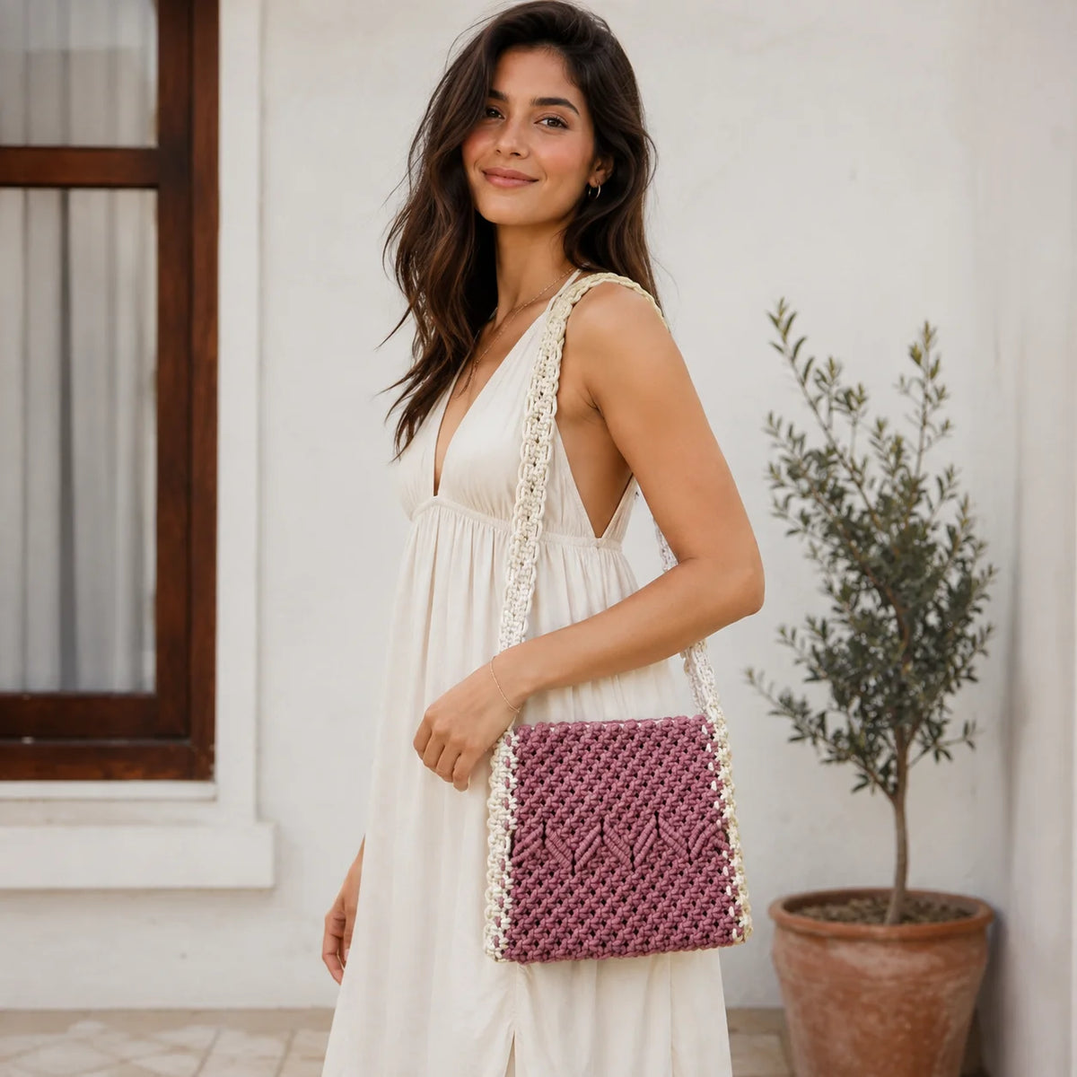 "Dusty mauve and cream 
macramé bag featuring an intricate geometric woven pattern and a wide braided macramé strap."
