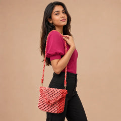 "Peach pink macramé 
sling bag featuring a chunky woven texture, decorative fringe detailing, an envelope-style flap, and a long braided strap."
