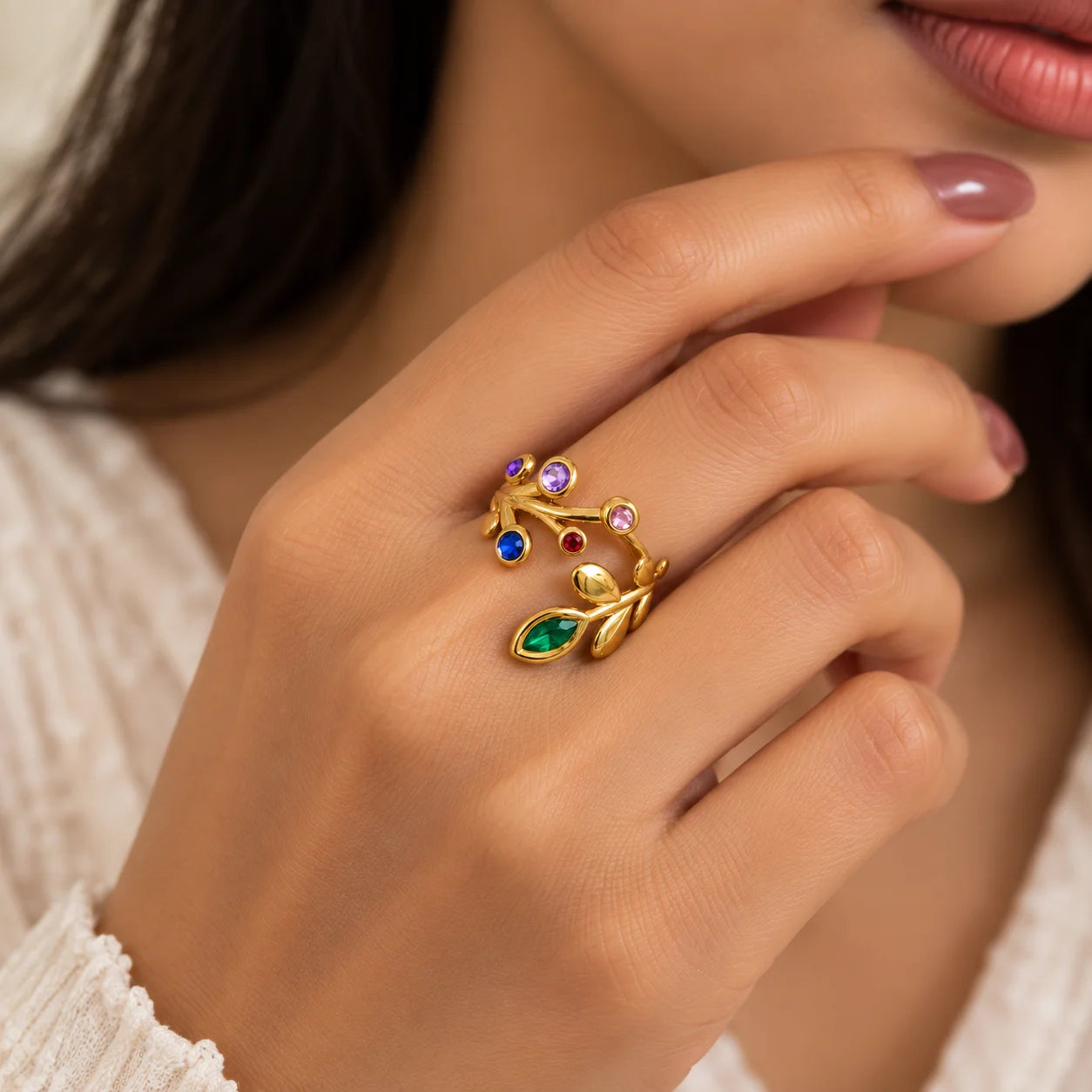 "Gold-toned open
 ring featuring a delicate leaf-inspired design with colourful pink, purple, blue, red, and green gemstone accents."
