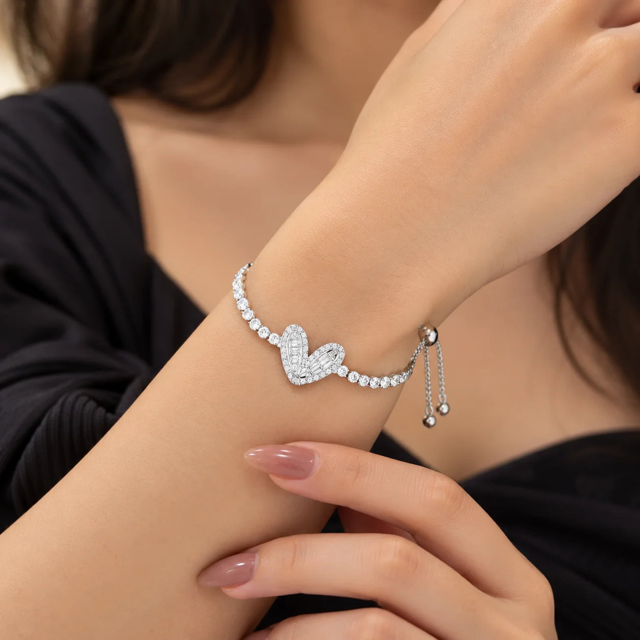 "Silver-toned bracelet
 featuring a sparkling heart-shaped centerpiece with intricate crystal-style detailing and a delicate chain with shimmering stone accents."
