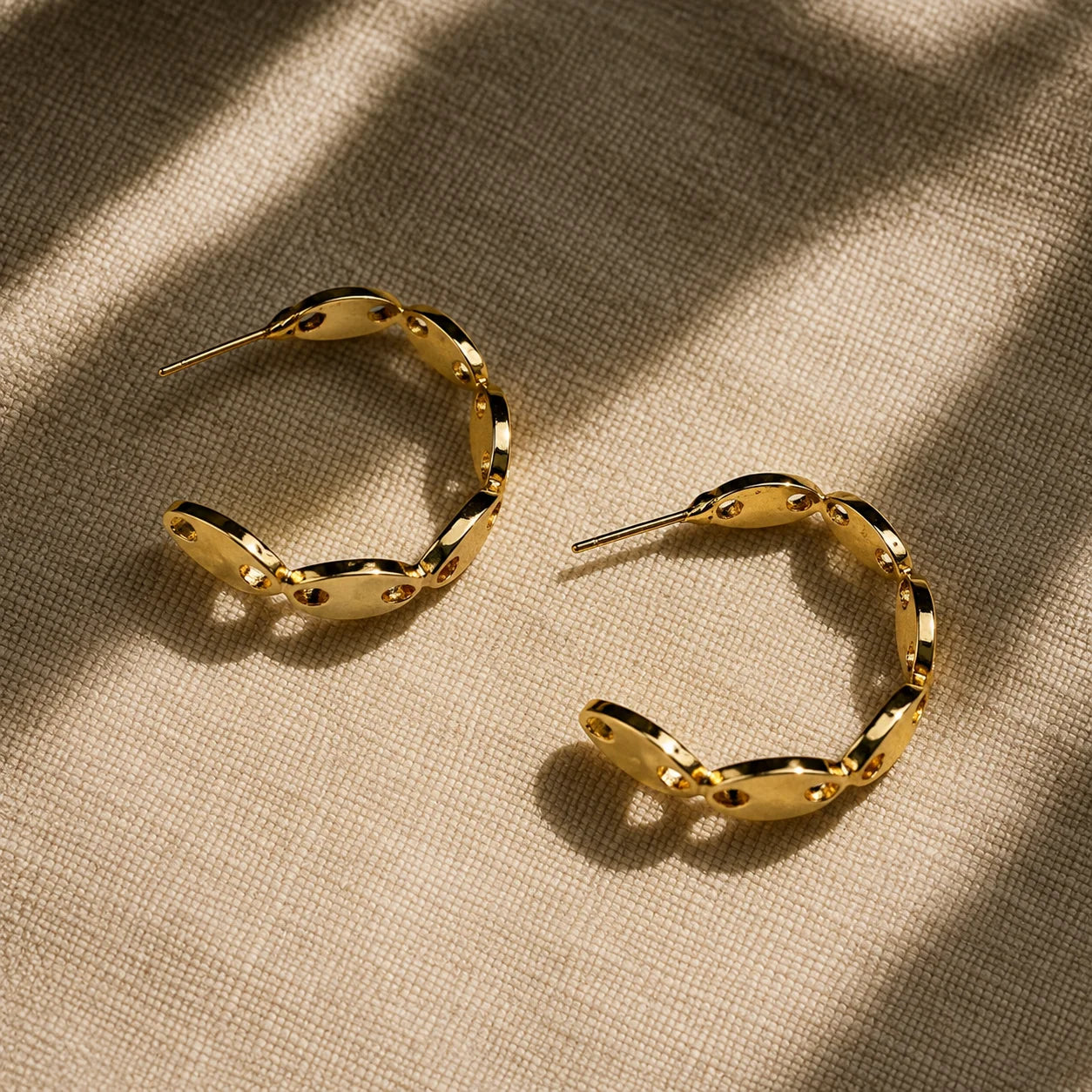 " Golden hoop earrings
 featuring a sculpted wave
design with polished gold-tone
 finish and stylish cut-out
 detailing. Lightweight 
statement earrings for
 women, perfect for everyday
 wear, office, parties, and
 festive occasions."
