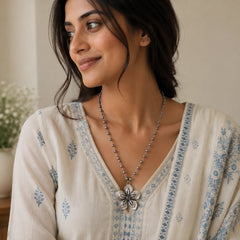 "Oxidised silver-tone
 necklace featuring a beaded chain and an intricate floral pendant with a vintage-inspired finish."
