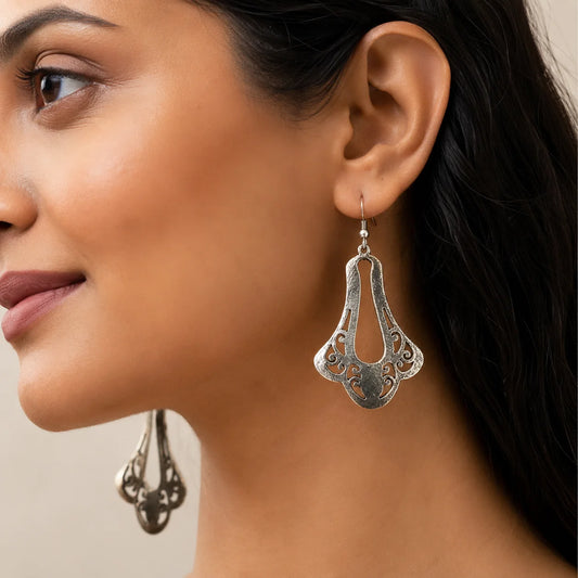 "Oxidised silver-tone 
earrings featuring an elongated abstract cutwork design with a bold bohemian-inspired silhouette for women."
