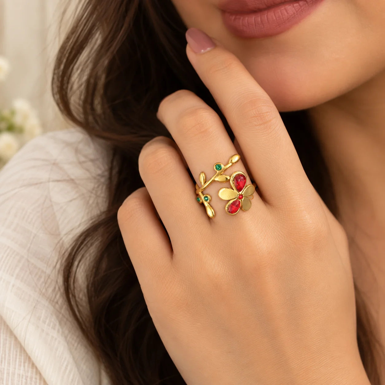 "Gold-toned open
 floral ring featuring a delicate vine design with vibrant red and green gemstone accents."

