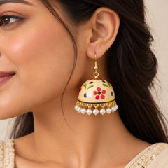 Cream Meenakari jhumka earring with multicolour floral motifs, gold-tone detailing, and dangling white pearl charms.
