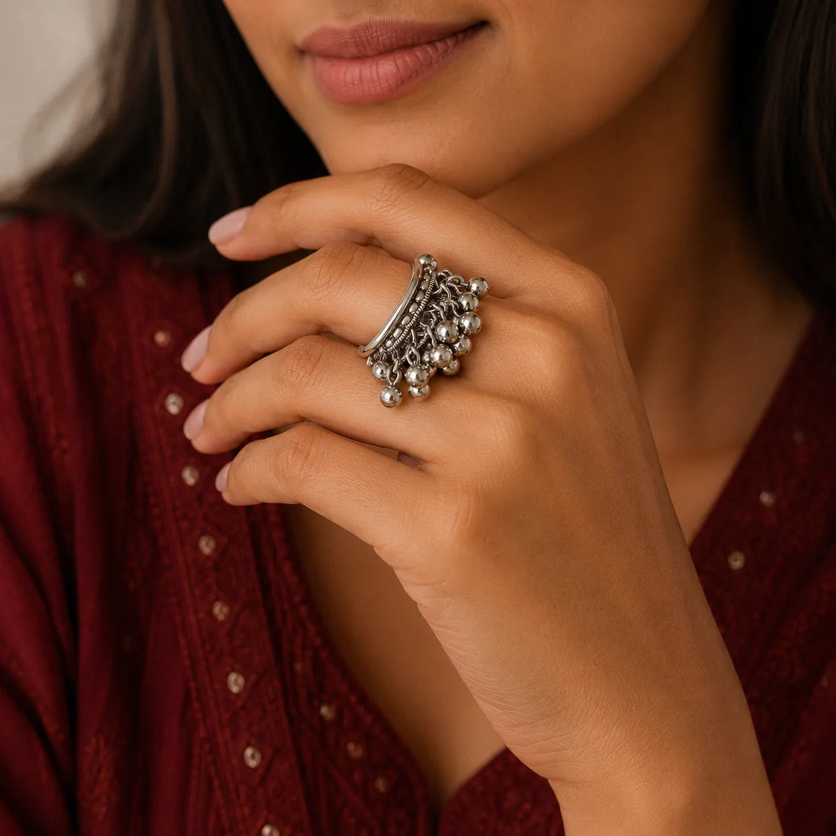 "Oxidised silver-tone 
statement ring featuring layered textured bands and multiple rows of delicate dangling silver beads."
