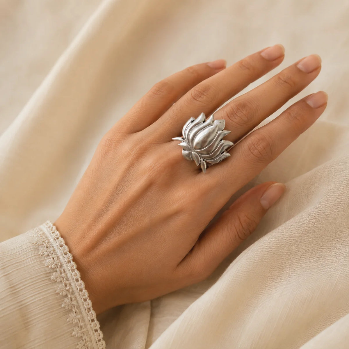 "Silver-tone oxidised 
statement ring featuring a large sculpted lotus flower design with layered petal detailing."
