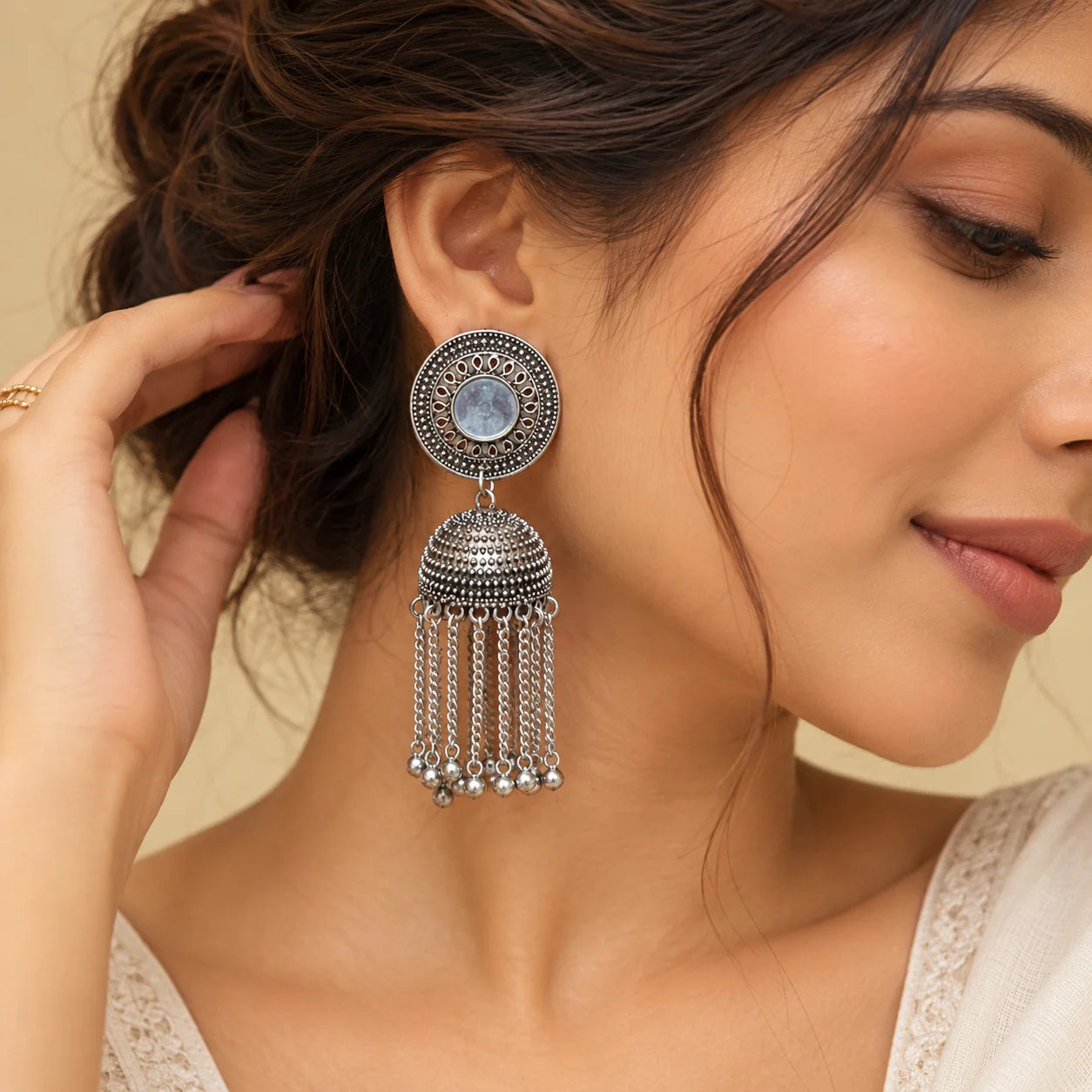 "Pair of oxidised silver 
jhumka earrings featuring intricate circular stud designs, textured dome-shaped jhumkas, and multiple cascading chain tassels with bead accents."
