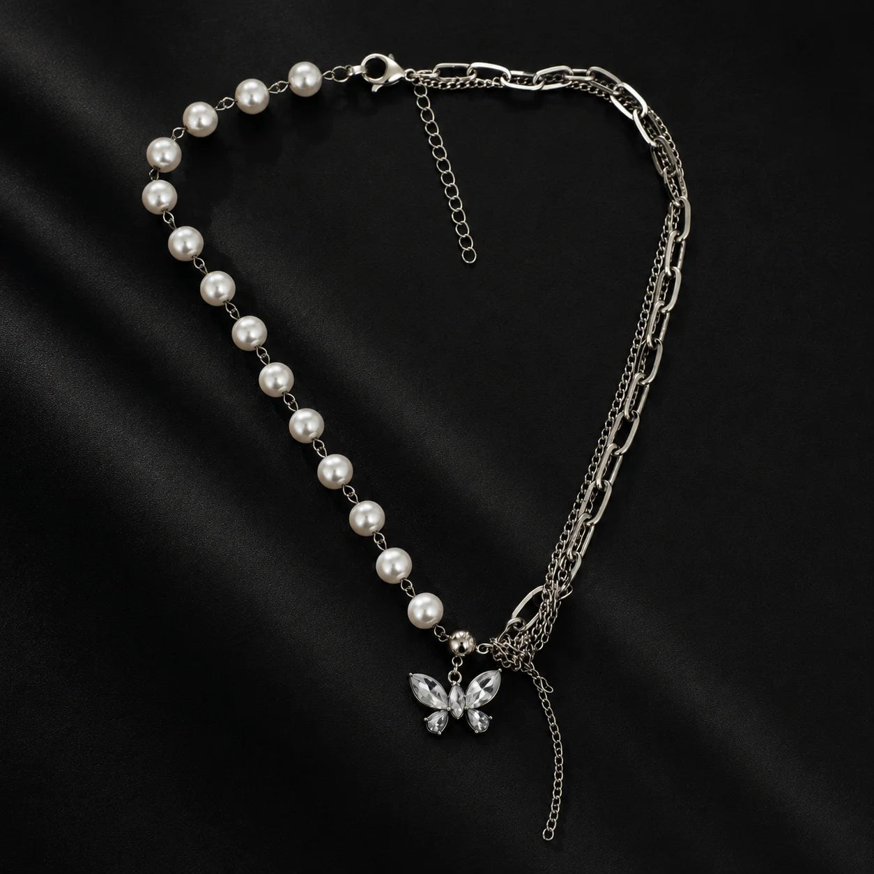 "Silver-tone statement necklace
 featuring a combination of faux pearl strand, chunky chain links, layered chains, butterfly charm, and tassel detailing, designed as a trendy layered necklace for women."
