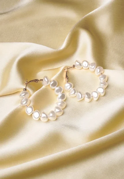 Chic metal hoop earrings featuring a polished gold boroque pearls, and a push back for easy wear
