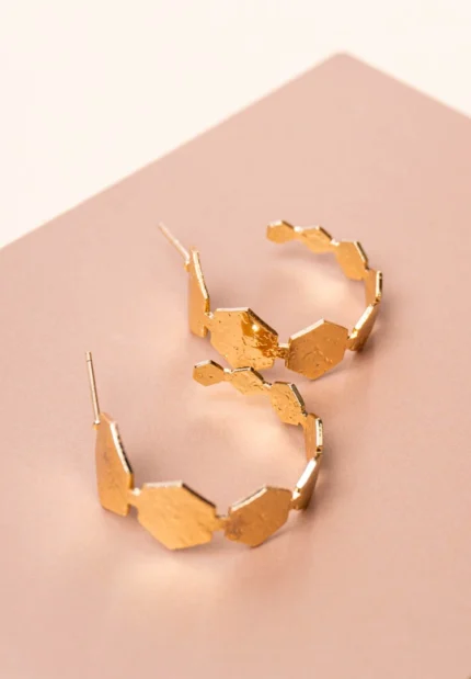 Trendy mini C-hoop earring with a polished gold-tone,geometric pattern finish, adorned with a hexagonal shaped design and , push-back post