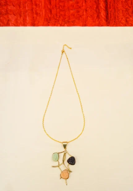 Stylish metal curb chain necklace with an organic-shaped pendant, enhanced with faceted blue teardrop stones, having a polished gold-tone finish, and a secure lobster claw clasp