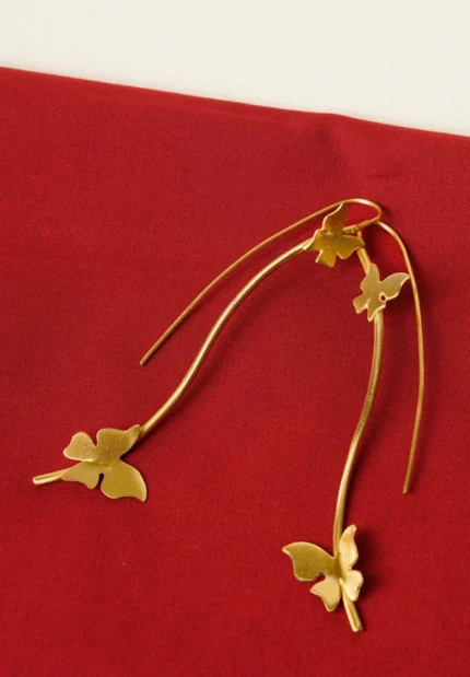 Modern geometric ring with a polished gold-tone finish also a round wire structure, and a emerald-green stone in the middle.