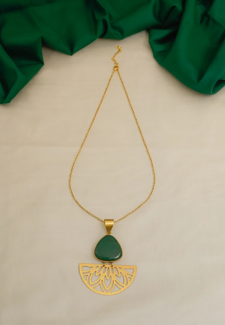 303-Th Modern yet vintage-inspired geometric flat cable chain necklace with a brushed gold-tone finish, featuring a bold triangular pendant set with a green stone, linked to a gracefully dangling semi-circular charm with delicate floral engravings, finished with a secure lobster claw clasp