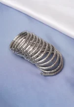 Contemporary metal spiral bracelet with a refined gold/silver texture, showcasing a multi-layered structure and bead details at both edges.