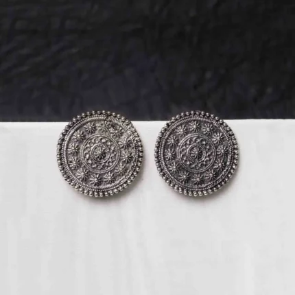 Vintage-inspired oxidized gold-tone circular dangle earring with a textured floral motif, flowing chain tassels, and a comfortable curved hook.