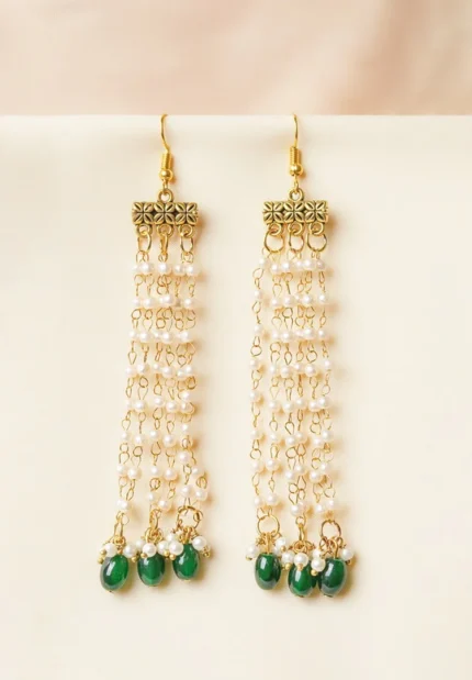 Statement gold tassel earrings featuring a delicately engraved rectangular bar design, fluid chain tassels for an elegant floral effect and designed with evenly spaced small pearl beads, a oval green colored circular shaped beads at the end and a curved hook closure