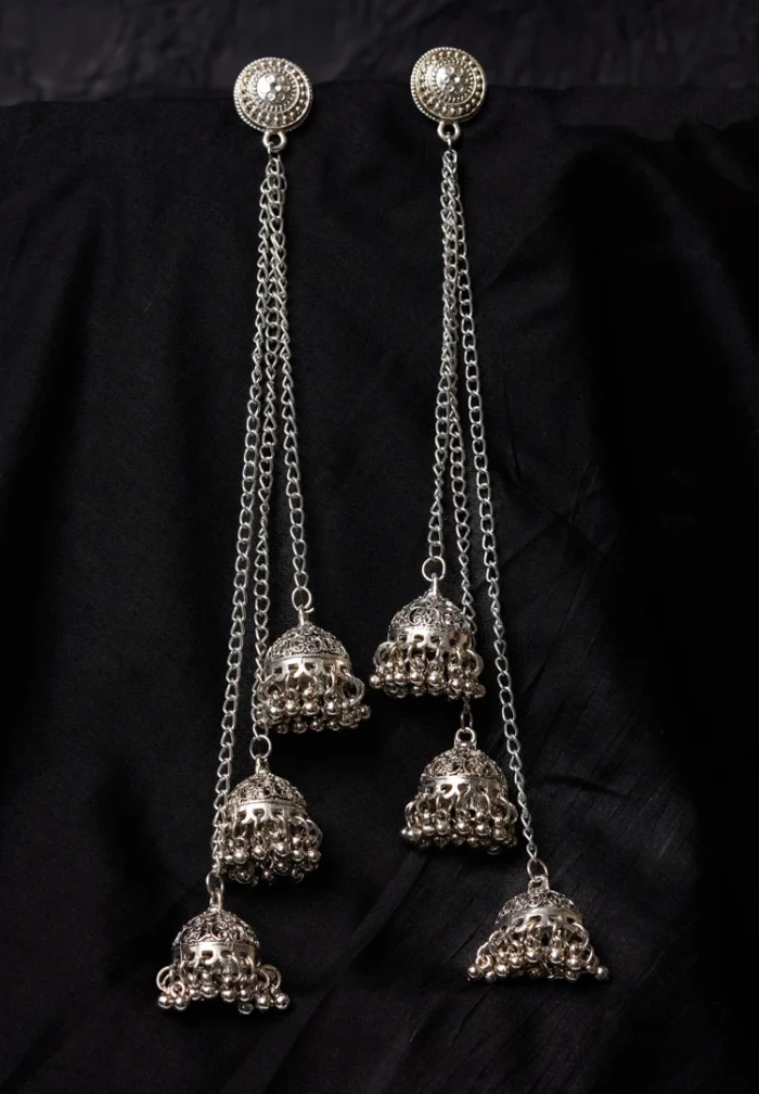 Vintage-inspired oxidized silver jhumka earring with an intricately detailed circular top, chain tassel layers, and small ghungroo embellishments and a push back closure.