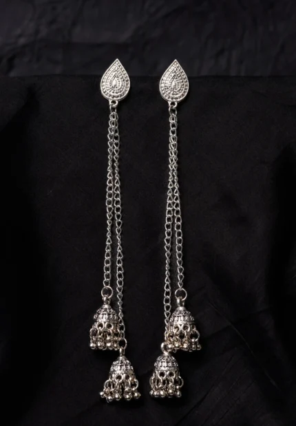 Vintage-inspired oxidized silver jhumka earring with an intricately detailed circular top, chain tassel layers, and small ghungroo embellishments and a push back closure