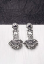 Traditional oxidized silver dangle earring featuring a finely crafted floral top detailing with gold-toned , elegant crescent shaped, and symmetrical geometric elements adorned with ghungroos at the end, and push back post.