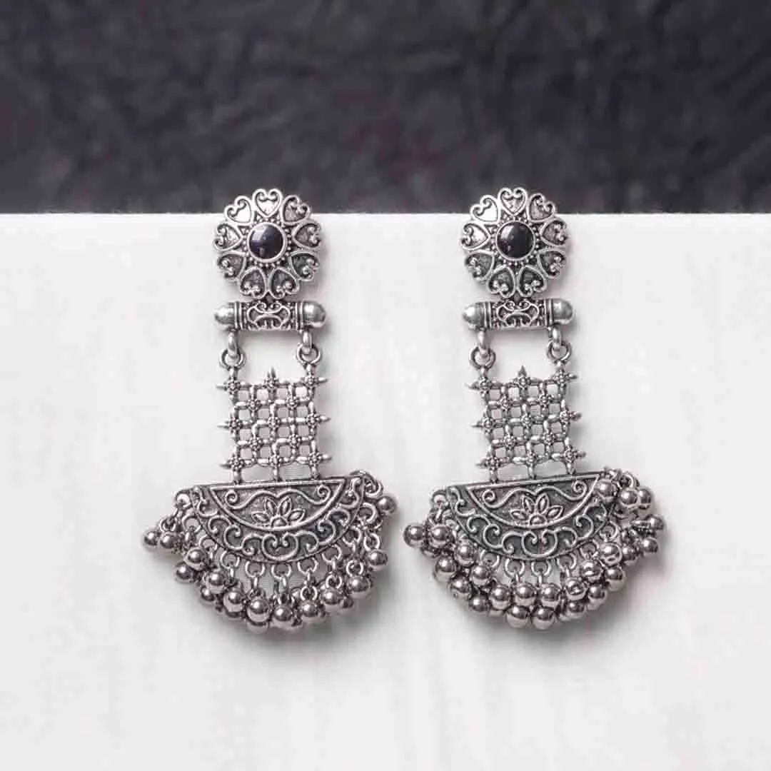 495-Th Traditional oxidized silver dangle earring featuring a finely crafted floral top detailing with gold-toned , elegant crescent shaped, and symmetrical geometric elements adorned with ghungroos at the end, and push back post.