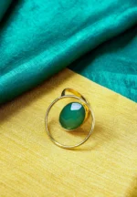 Modern geometric ring with a polished gold-tone finish also a round wire structure, and a emerald-green stone in the middle