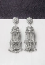 Oxidised jhumka earrings with complex floral detailing, featuring a finely detailedchain tassels, and ghungroos at the bottom, secured with a curved hook closure.