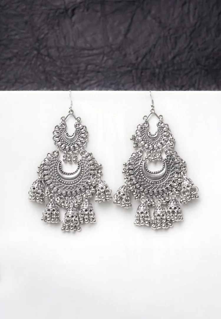 528-Th Fusion-style oxidised silver dangle earring featuring interconnected crescent elements, adorned with small jhumka-inspired details and ghungroos for a traditional touch, secured with a curved hook closure.